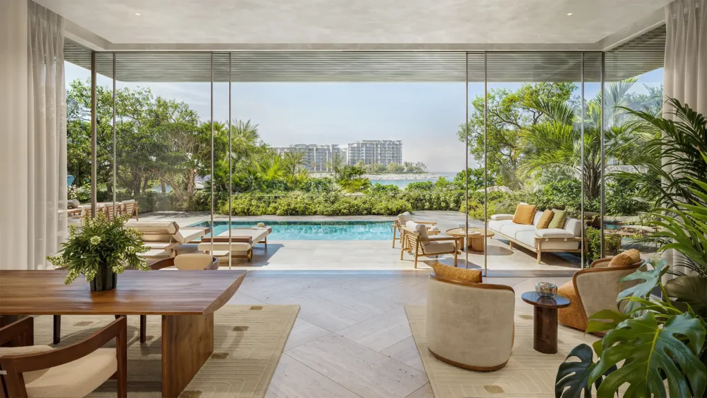 Modern luxury interior at Solaya La Mer opening to a private pool terrace, surrounded by lush greenery and with a distant view of the ocean.